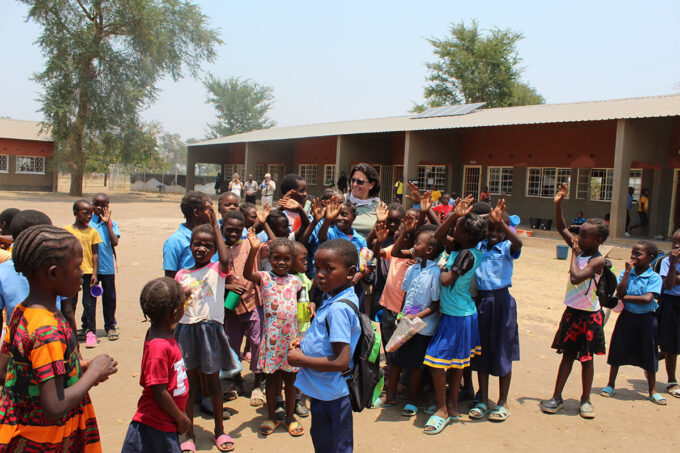 Children in Zambia outside their new school smiling