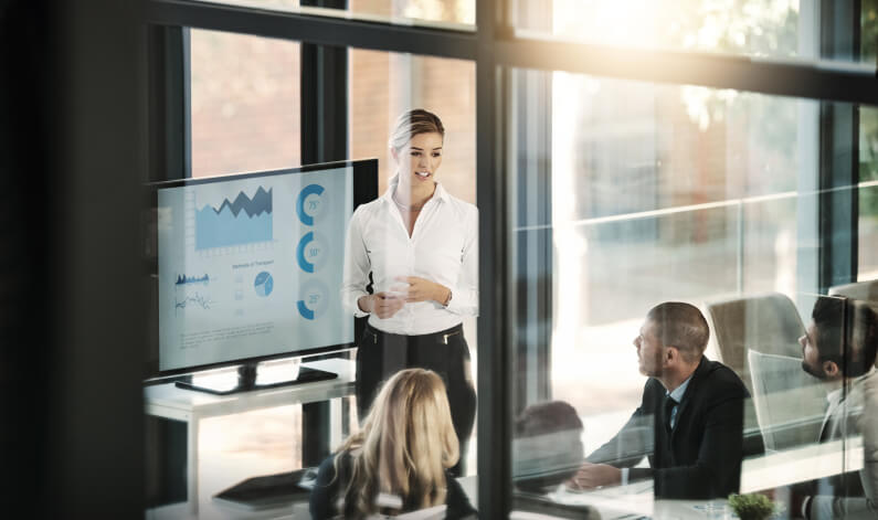 Woman presenting charts at a company meeting
