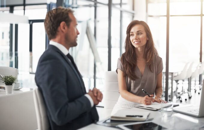 two professionals speaking at a table