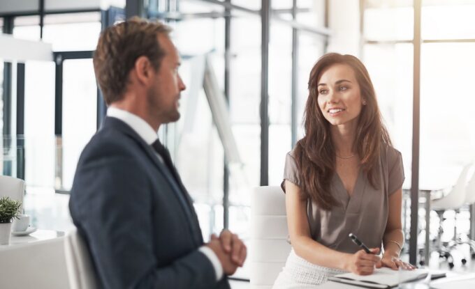 two professionals speaking at a table