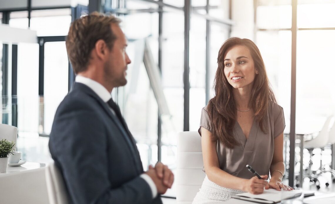 two professionals speaking at a table